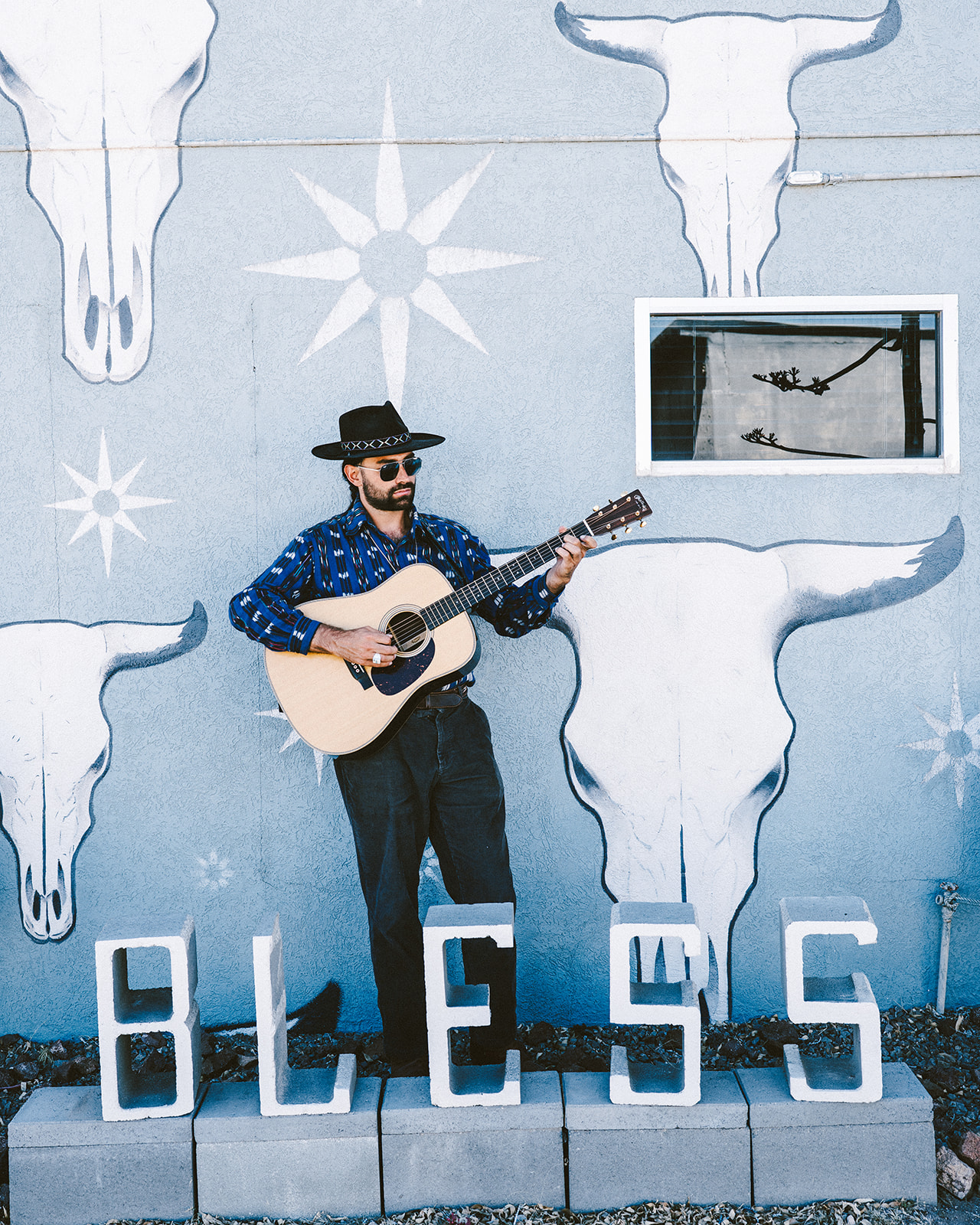 Duane with guitar by a colorful mural